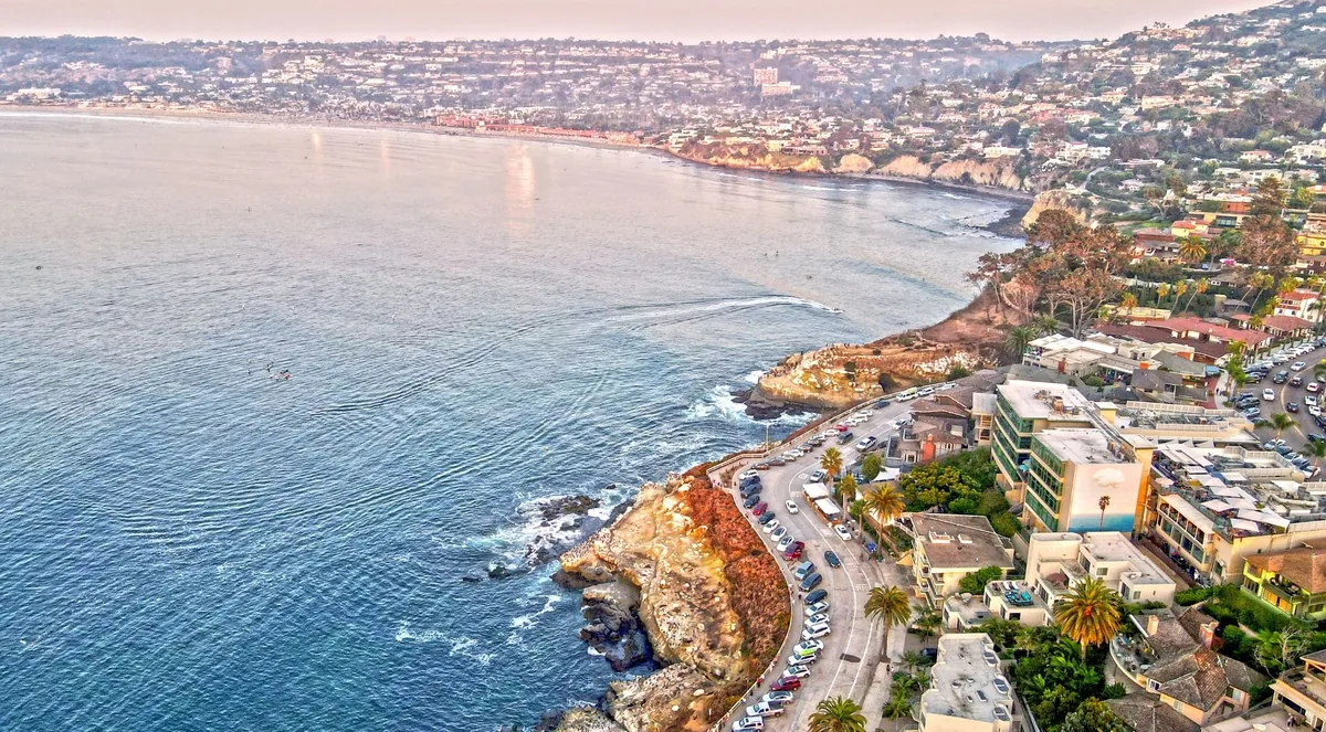 Aerial view of the La Jolla coastline curving north past cliffs toward a long sandy beach